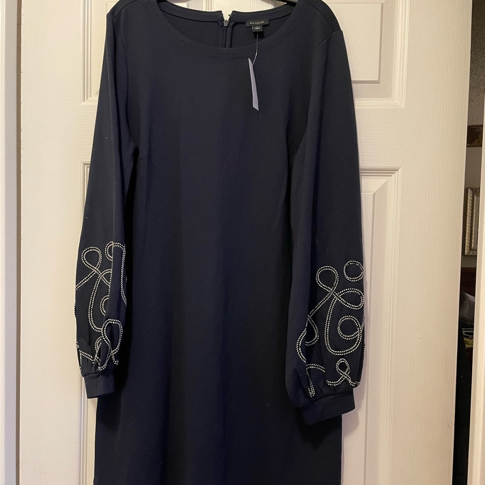 Navy dress with full-length zipper in back; long sleeves with decorative detail.